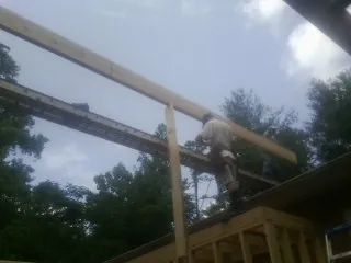 Carpenter setting a ridge beam over a new addition frame — Ice Dam Removal by Roofing Brothers in Parsons