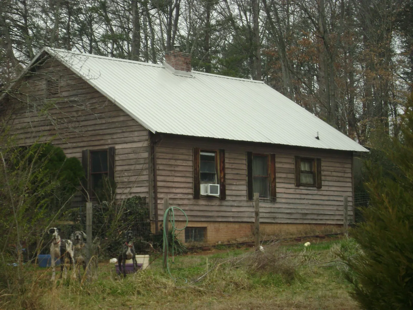 White metal roof on an old wood sided farmhouse, from a Metal Roof Installation job in Parsons